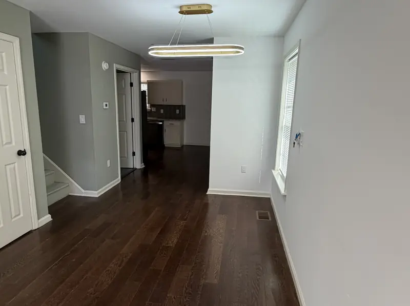 Hallway and living area of a Louisville rental with clean, freshly painted walls and refinished floors