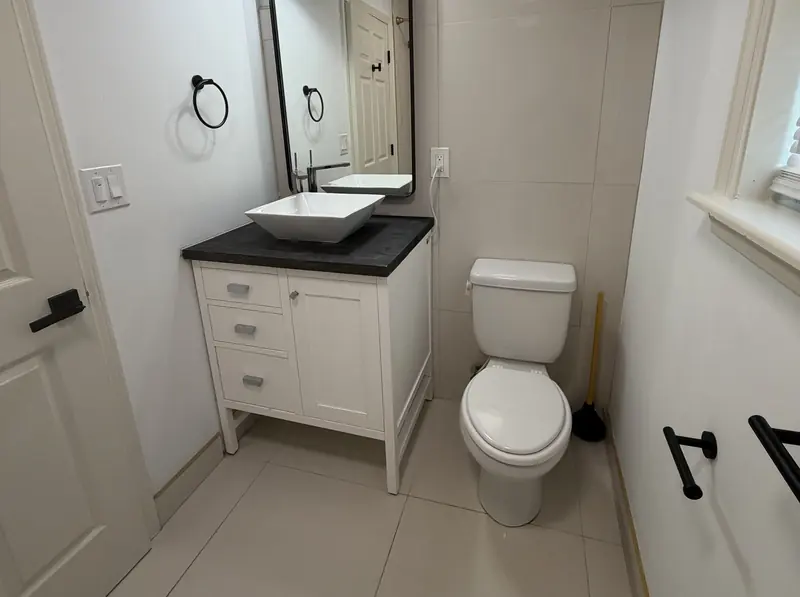 Bathroom in a Louisville rental with a new vanity, toilet and black hardware