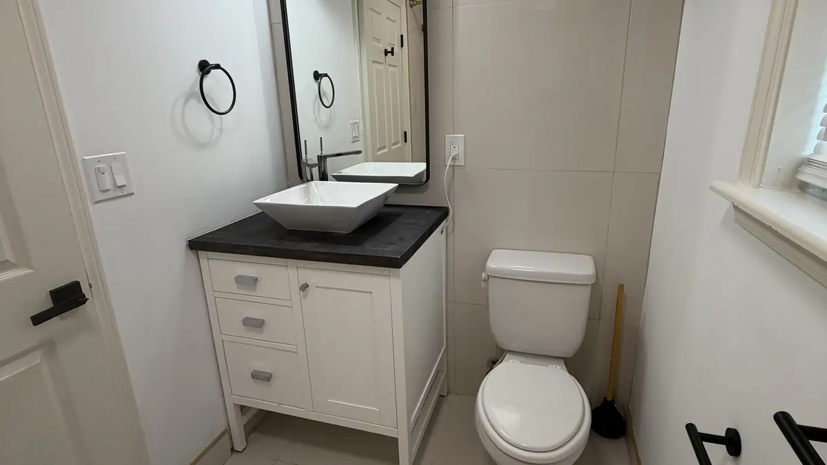 Bathroom in a Louisville home with a new vanity and light, finished by The Tenant Turn