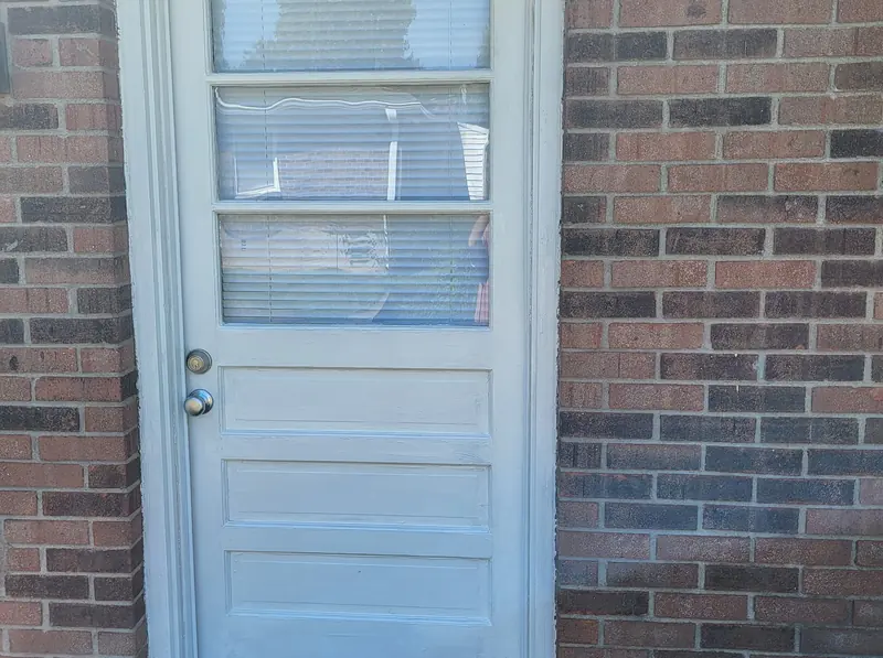 White painted door and trim set in a brick wall at a Louisville house